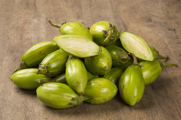 Some green african eggplants over a wooden surface