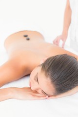 Fototapeta na wymiar Beautiful brunette enjoying a hot stone massage 