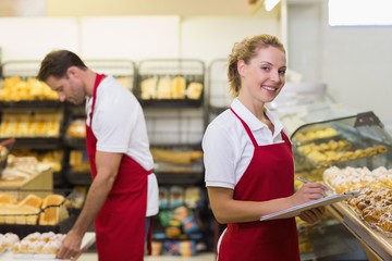 Portrait of a blonde baker with her colleague 