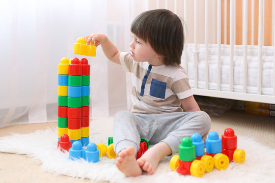 Cute little boy plays plastic blocks