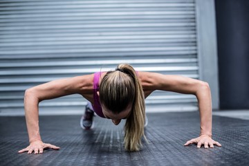 Fototapeta na wymiar Muscular woman doing push ups
