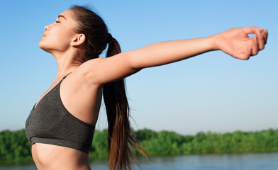 Happy asian woman raising arms to the sky.