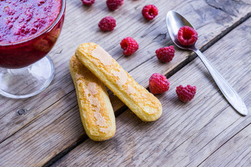 Raspberry jam and fresh raspberry on the wooden table