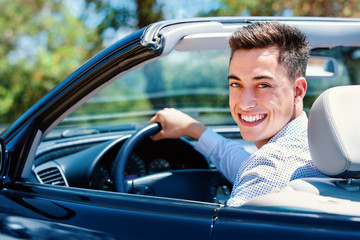 Portrait of young man sitting in car.
