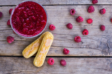 Raspberry jam and fresh raspberry on the wooden table