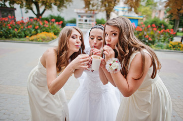 Young bridesmaid with bride drinking coffee