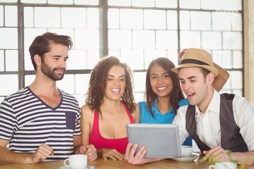 Smiling friends looking at tablet computer