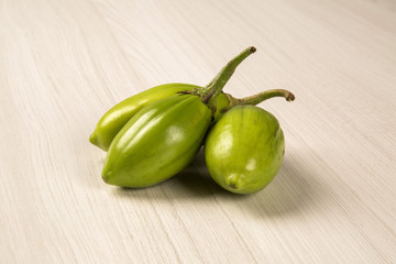 Some green african eggplants over a white background