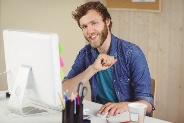 Happy hipster working at his desk