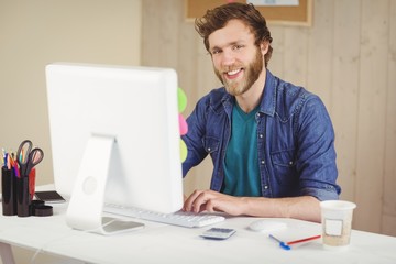 Happy hipster working at his desk