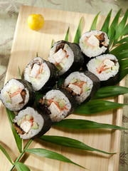 sushi roll futomaki with shiitake mushroom, omelet, cucumber and ginger served on wooden board. japanese food