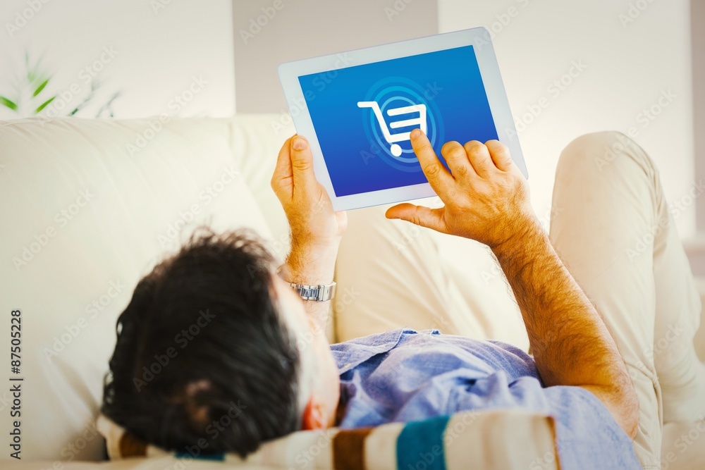 Poster composite image of man laying on sofa using a tablet pc