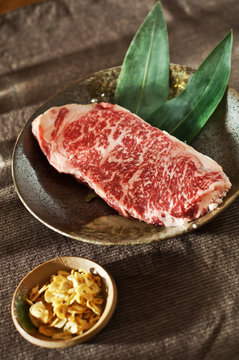 Raw fresh marbled meat Black Angus Steak. Japanese Kobe veal with garlic chips