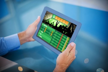 Composite image of businessman using his tablet 