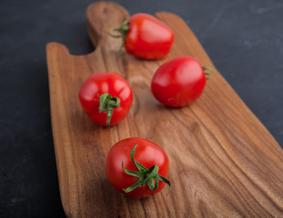 Ripe red tomatoes on cutting board
