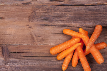 Carrots bunch shot on a wooden background from above with negative space