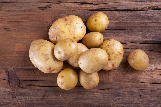 Potatoes bunch shot on a wooden background from above