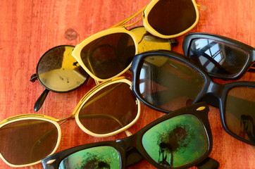 Set of vintage sunglasses on brown wooden background