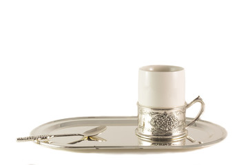 White porcelain coffee Cup with silver spoon on tray