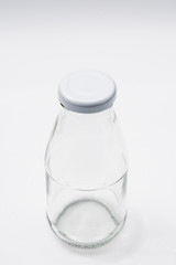 Empty colorless glass bottle on White Background