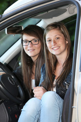 Deux adolescentes souriantes assises dans une voiture