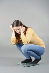 junge Frau auf Waage, abnehmen, Diät, Schreck, Schock, überrascht, deprimiert,