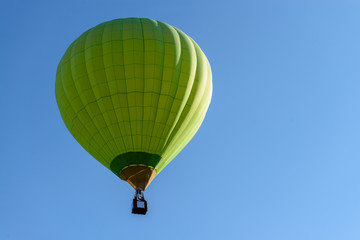 Naklejka premium Green hot air balloon in blue sky