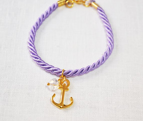 still life of a purple bracelet with anchor