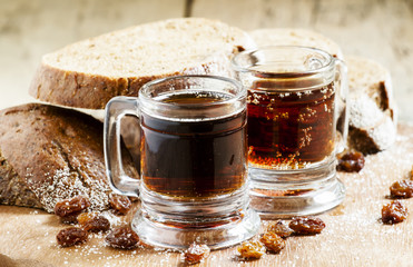 Traditional Russian drink kvass in a mug, with rye bread on a wo - obrazy, fototapety, plakaty