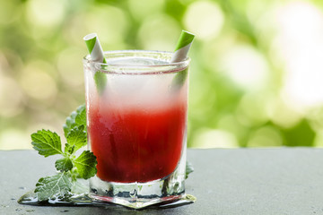 Frozen red cocktail with mint on the sun deck on a summer day, s