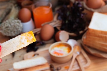 soft-boiled egg with bread on wood background.