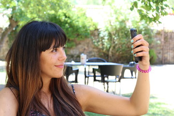 Young woman taking selfie outside 