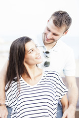 Funny couple laughing with a white perfect smile and looking each other outdoors with unfocused background. Love concept