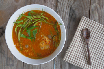 Sour soup made of tamarind paste with fish roe on the wooden table, Thai food