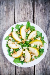 fresh salad with arugula, pear, walnuts and blue cheese