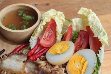 Instant noodles soup put crispy pork and egg