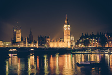 Vintage filter style London skyline at night with Big Ben and Thames 