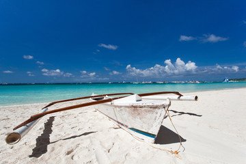 Wooden boat on tropical beach with white sand