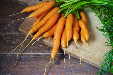 Fresh Organic Carrots on wooden background.