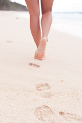 Woman walking through sand on the beach