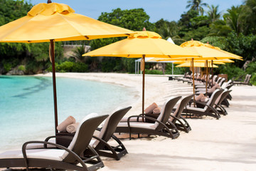 Sun umbrellas and beach chairs on tropical beach