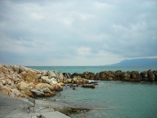 Coastal landscape on the Greek peninsula Pelion, with rocky beach and dramatic sky, just after rain, in early autumn.