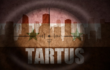 sniper scope aimed at the abstract silhouette of the city with text Tartus at the vintage syrian flag. concept