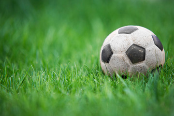 Old and classic Soccer ball or football ball on green field