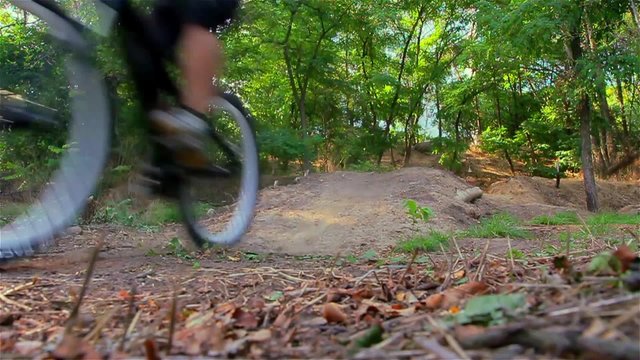 Biker jump and passes near camera