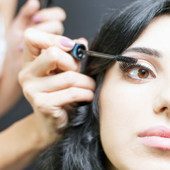 makeup artist doing make up for beautiful arabian woman