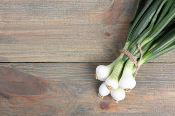 Bundle onions  on a brown wooden table