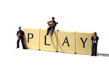 Miniature musicians play.
Scale model miniature musicians with the word play on tiles.