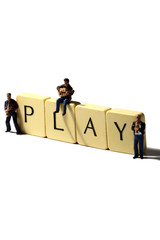 Miniature musicians play.Scale model miniature musicians with the word play on tiles.