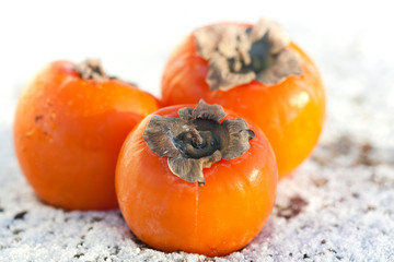 Delicious persimmons on white snow